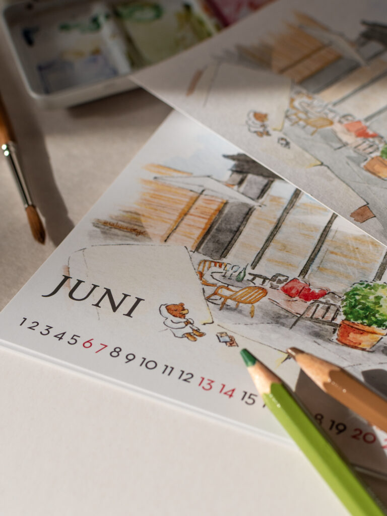 Nahaufnahme vom Juni, Stifte verdeckten das Baltt zur Hälte, die original Zeichnung liegt auf dem Motiv, zu sehen ist eine Dachterrasse mit Teddy auf der Sonnenliege