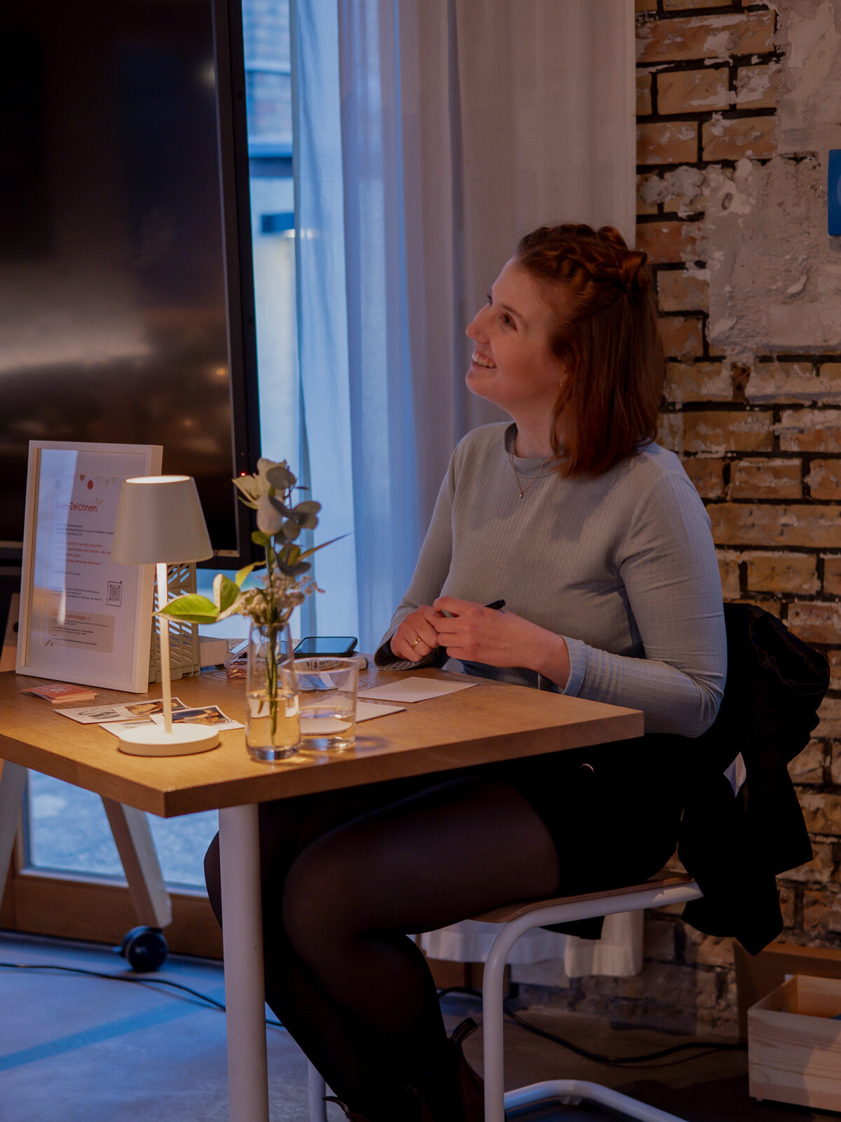 Malina am Tisch bei Live Zeichnen Event sitzend und sich unterhaltend