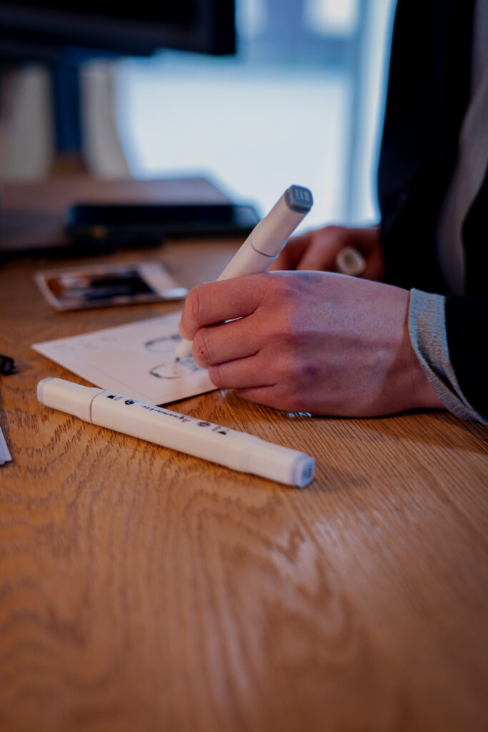 Nachaufnahme von Malina. Man sieht ihr linke Hand zeichnend